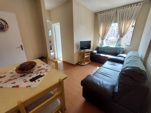 Sala bem iluminada com dois sofás e uma mesa de jantar.