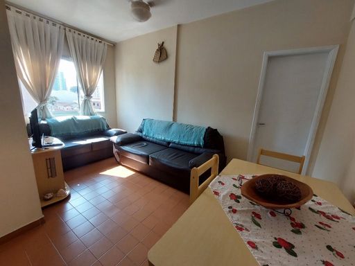 Sala bem iluminada com dois sofás e uma mesa de jantar.