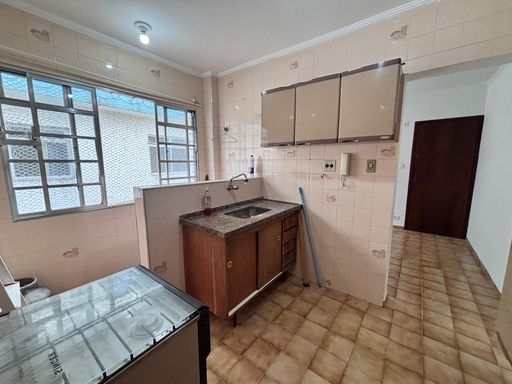 Cozinha bem iluminada com uma pia, gabinete e fogão.