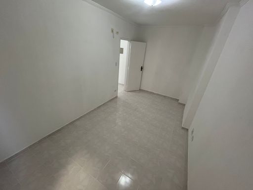 Dormitório espaçoso com paredes brancas.