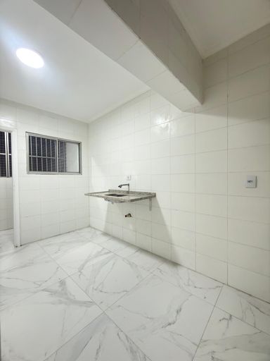 Cozinha espaçosa e branca com uma pia.