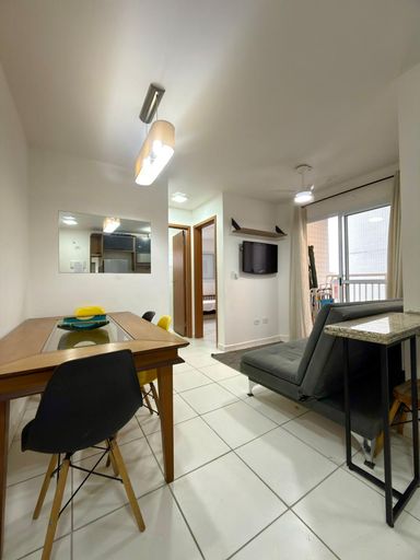 Sala com uma mesa de jantar e sofá cama.