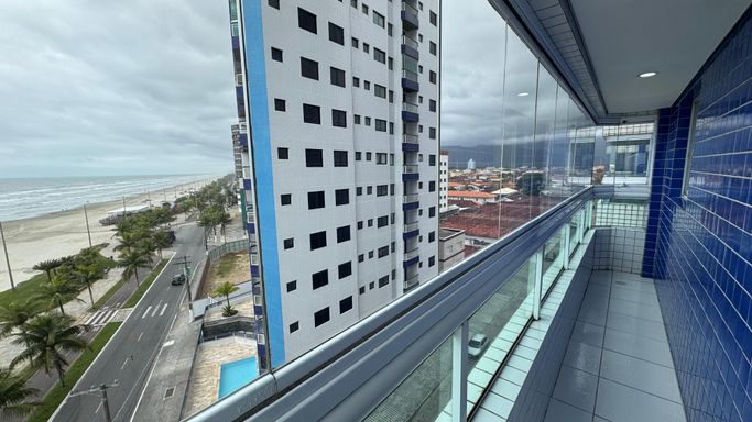 Sacada gourmet envidraçada com vista para o mar.