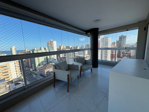 Sacada gourmet envidraçada com vista para o mar.