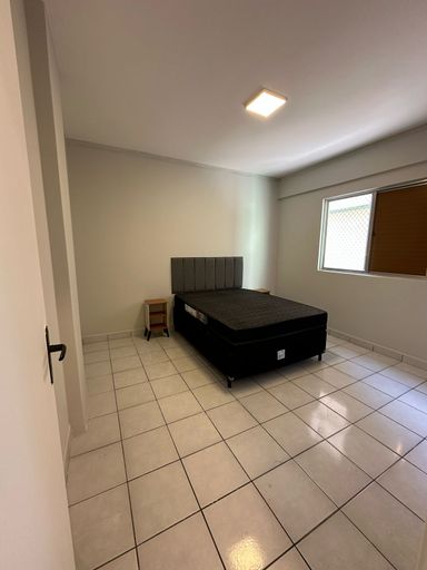 Dormitório com uma cama de casal e dois criados-mudos.