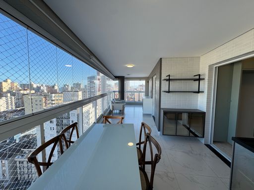 Sacada gourmet envidraçada com vista para o mar.