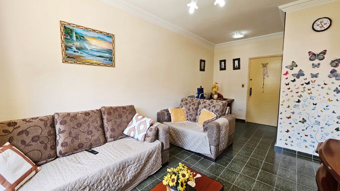 Sala ampla e bem iluminada com ventilador de teto e dois sofás.