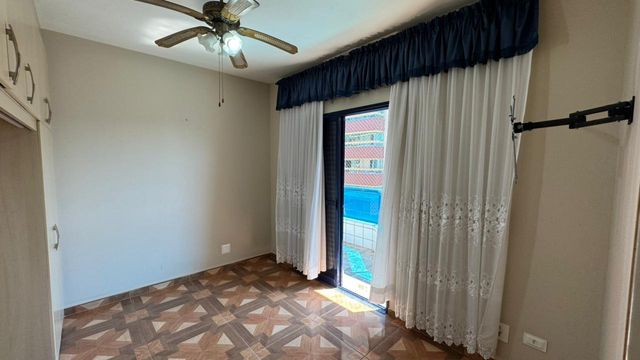 Suíte planejado com ventilador de teto e uma sacada privativa.