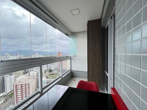 Sacada gourmet envidraçada com vista para o mar.