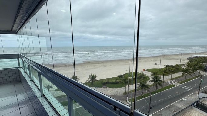 Sacada gourmet envidraçada com vista para o mar.