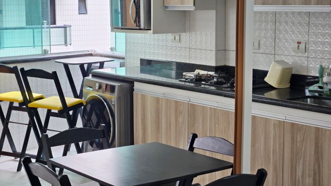 Cozinha com armários planejados e maquina de lavar roupa.