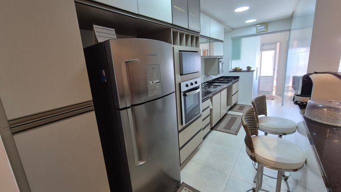 Cozinha americana com armários planejados.