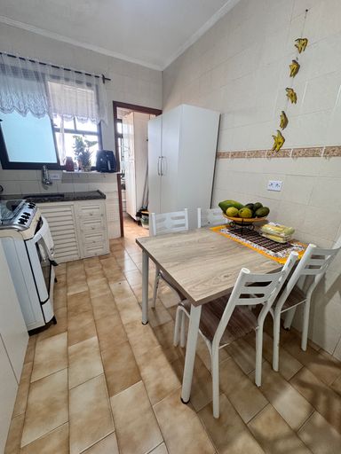 Cozinha espaçosa com pia, gabinete, fogão, geladeira e mesa para 04 pessoas.