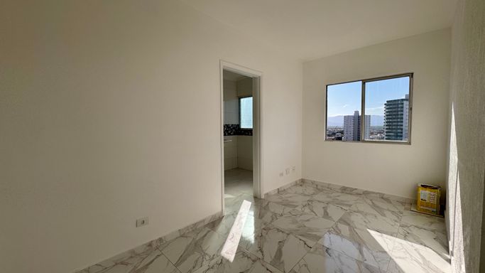 Sala bem iluminada com janela grande com vista livre.