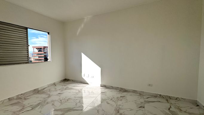 Sala bem iluminada com janela grande com vista livre.