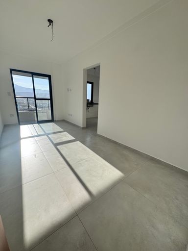 Sala bem iluminada com sacada.