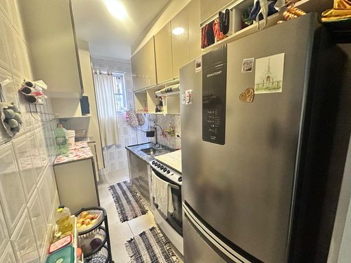 Cozinha com armários planejados e uma geladeira.