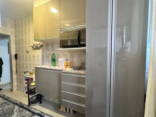 Cozinha com armários planejados e uma geladeira.