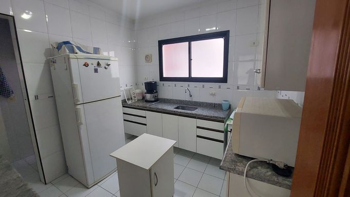 Cozinha com armários brancos.