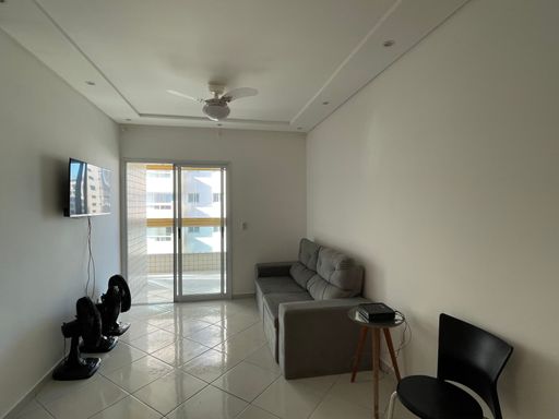 Sala ampla de 2 ambientes com mesa de jantar e um sofá.