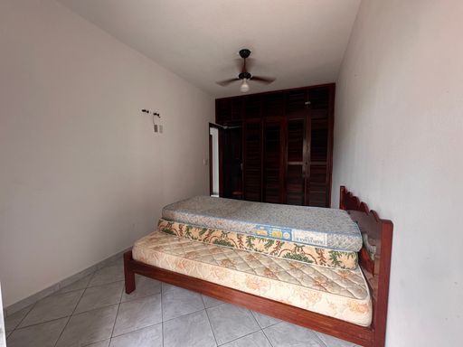 Dormitório com 1 cama de casal e 2 colchões de solteiro, armário embutido, ventilador de teto e acesso a sacada.