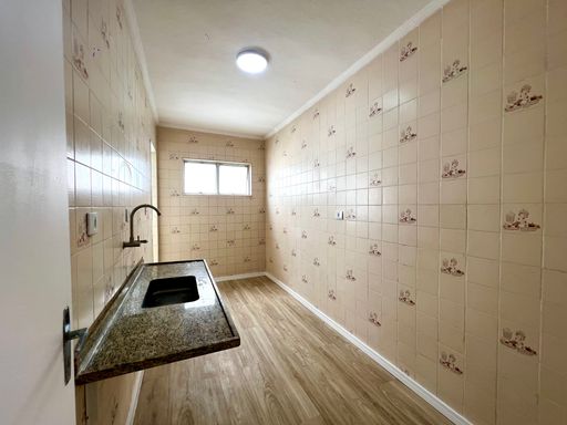 Cozinha com piso vinílico e uma pia.