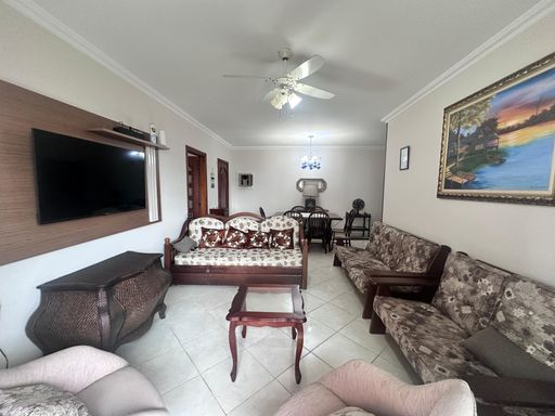 Sala de dois ambientes com 03 sofás, dois poltronas e sacada.