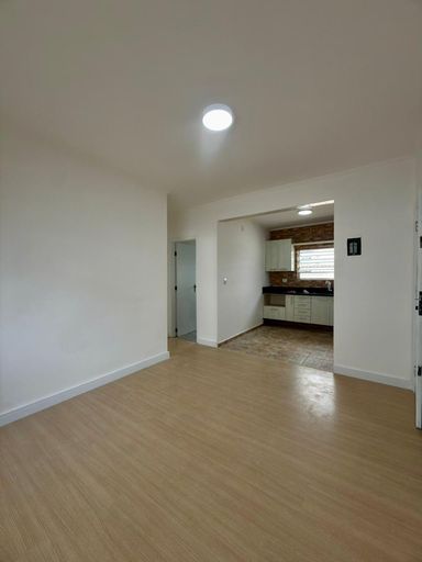 Sala bem iluminada com piso laminado.