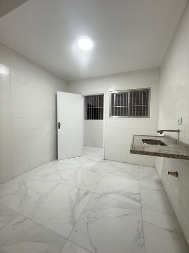 Cozinha espaçosa e branca com uma pia.