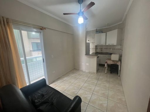 Sala bem iluminada com sofá cama e ventilador de teto.