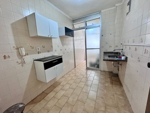 Cozinha com uma pia e armários brancos.