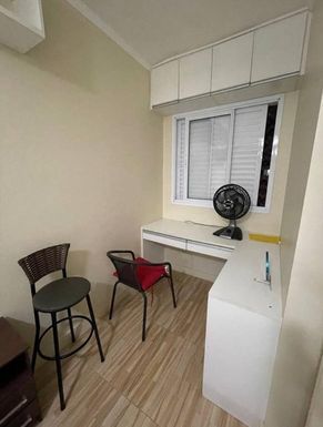 Dormitório espaçoso com guarda-roupa planejada e ventilador de teto.