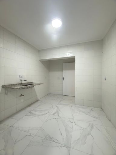 Cozinha espaçosa e branca com uma pia.