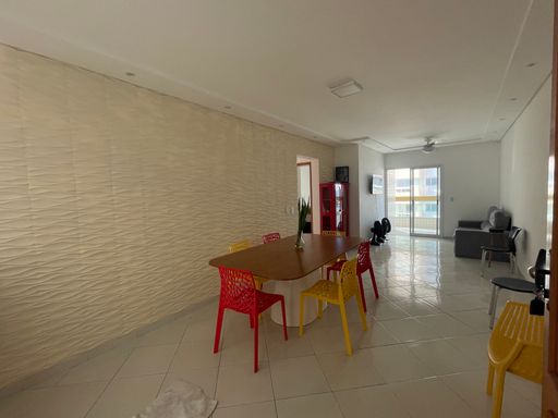 Sala ampla de 2 ambientes com mesa de jantar e um sofá.