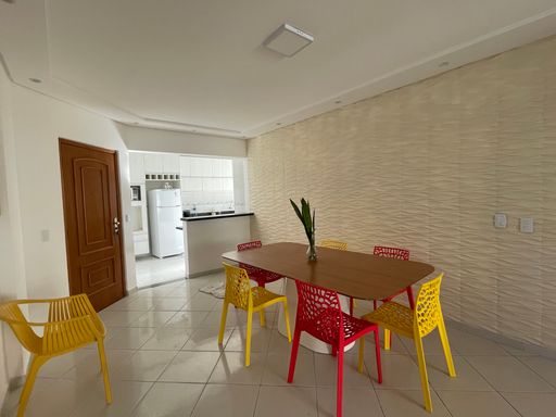 Sala ampla de 2 ambientes com mesa de jantar e um sofá.