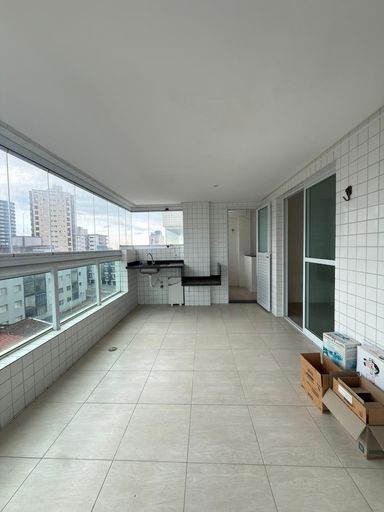 Sacada gourmet envidraçada com vista para o mar.