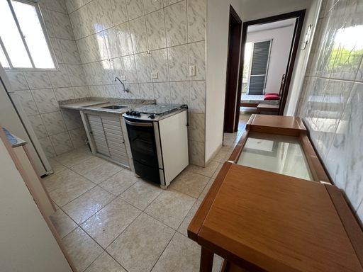 Cozinha com uma, pia, gabinete embutido, fogão e armários.