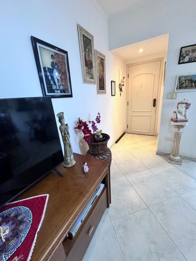 Sala de 2 ambientes com vista para o mar, mesa de jantar e ventilador de teto.