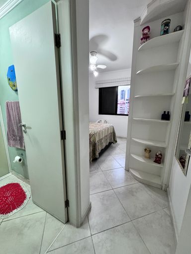 Suíte com 1 cama de casal com ventilador de teto e armários planejados.