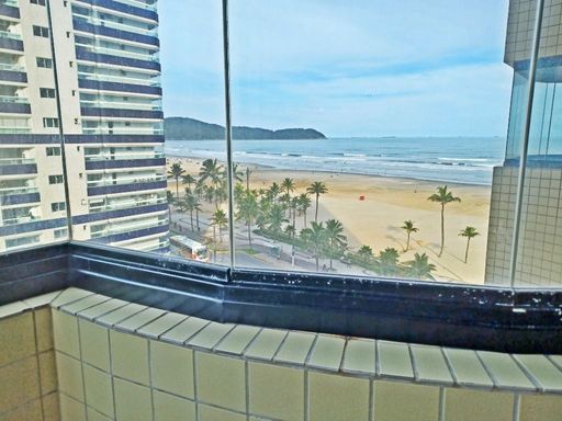 Sacada envidraçada com vista para o mar.
