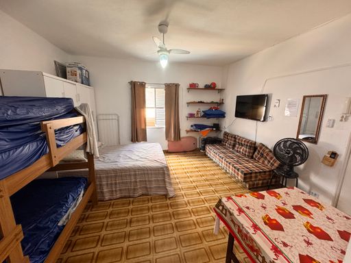 Sala living ampla e bem iluminada com ventilador de teto.