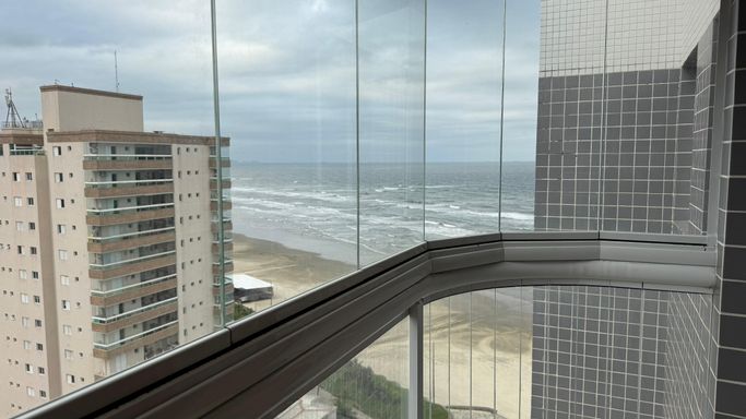 Sacada envidraçada com vista para o mar.
