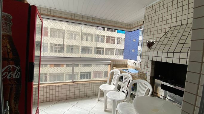 Sacada gourmet envidraçada com vista para o mar.