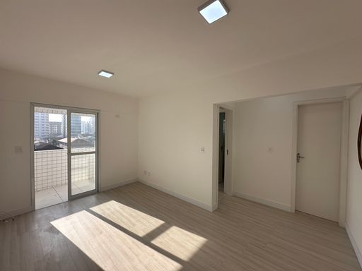 Sala muito bem iluminado com piso laminado.