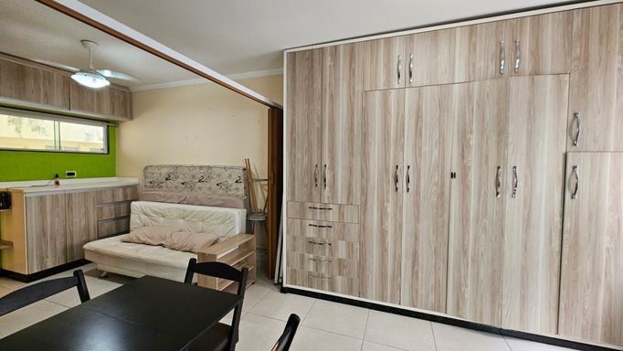 Sala living ampla com divisória para sala, cozinha e dormitório.