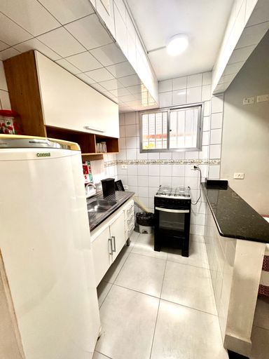 Cozinha americana com uma geladeira e fogão.