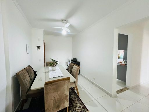 Sala ampla e muito bem iluminada com dois ventiladores de teto e mesa de jantar.