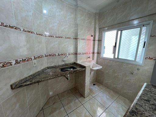 Cozinha americana com uma pia integrada com a área de serviço.