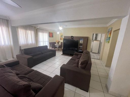 Sala ampla de dois ambientes com três sofás e ventilador de teto.