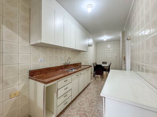 Cozinha ampla com armários planejados e mesa de jantar de 6 lugares.